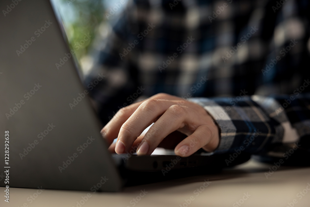Poster employee seated at home office desk using notebook, checking emails displayed on screen, reading mes