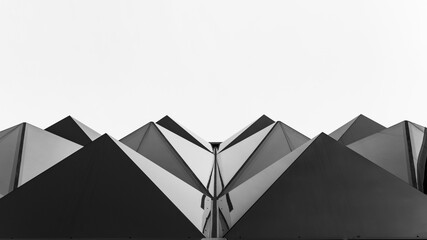 Stunning black and white photo of a modern pyramid glass facade against a light sky background,...