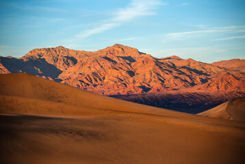 Sunset Light Over Sand Dunes And Mountains At Mesquite flat dunes, Death Valley National Park,...
