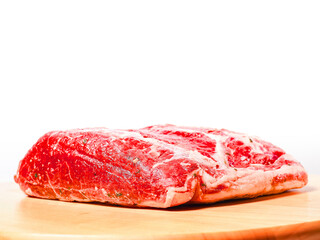 Top quality striploin roast on a wooden board. Premium expensive meat for cooking. Uncooked, raw beef meat in one big piece. Light color background.