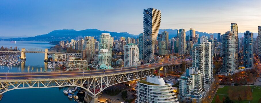 Vancouver skyline at dawn, featuring the iconic Granville Bridge, modern high-rises, and a vibrant harbor. City life at sunrise.  Vancouver, British Columbia, Canada