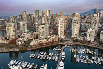 Fototapeta premium Vancouver skyline, marina, and yachts. City condos and boats reflect in the water. Beautiful morning light. , Downtown, British Columbia, Canada