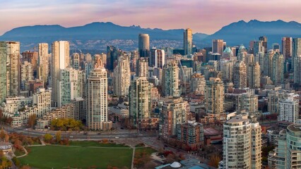 Naklejka premium Vancouver skyline at dawn, showcasing high-rise buildings and the city's urban landscape. Modern architecture against a backdrop of mountains. British Columbia, Canada