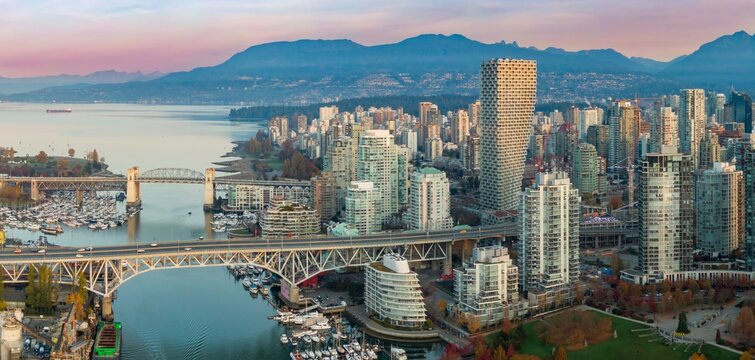 Vancouver skyline at dawn, showcasing the city's modern architecture and bridges. Urban landscape with high-rise buildings, boats, and a bridge. Granville Bridge, Vancouver, British Columbia, Canada