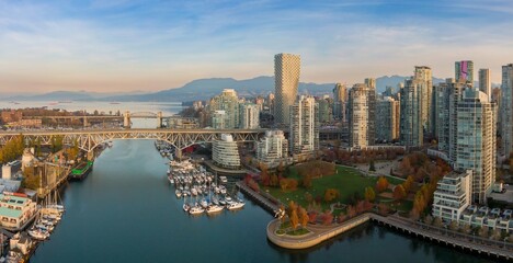 Obraz premium Vancouver skyline, harbor, and bridge. Boats in marina, park, and modern high-rise buildings. Aerial view of urban waterfront. Granville Bridge, Vancouver, British Columbia, Canada