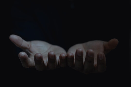 Closeup receiving gesture of outstretched cupped empty open hand. Concept of giving, donation, receiving, asking, and bribery. Give two hands with nothing on both on dark background with copy space.
