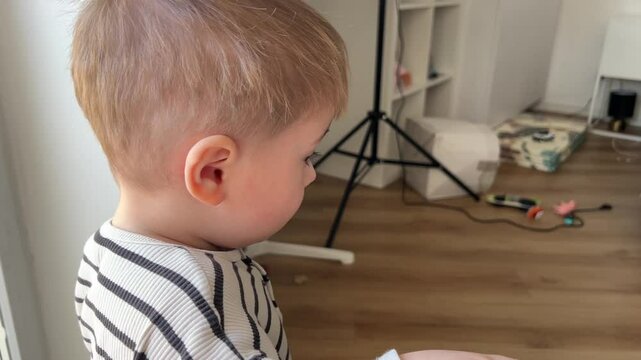 A small child looks at the camera with an emotion of surprise then walks away