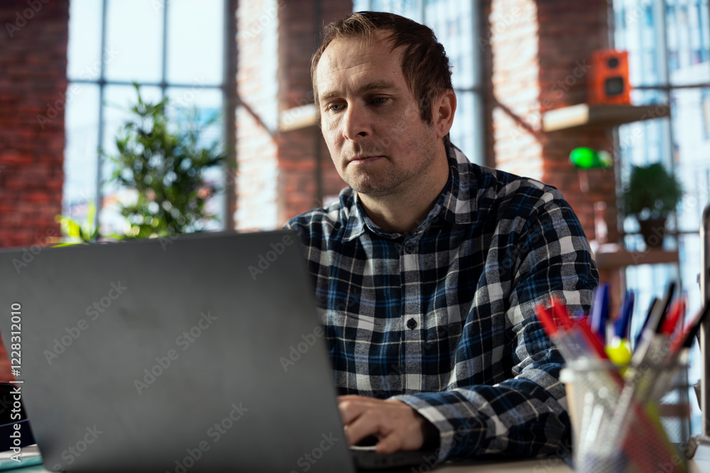 Poster person at home browsing internet on laptop, researching information online, accessing websites, read