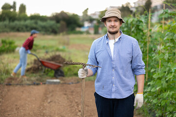Portrait of man holding a rake in a farmer field