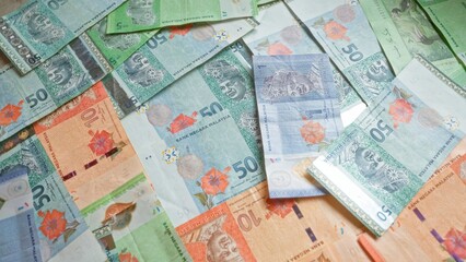 Colorful malaysian ringgit banknotes scattered on a flat surface, highlighting the vibrant currency...