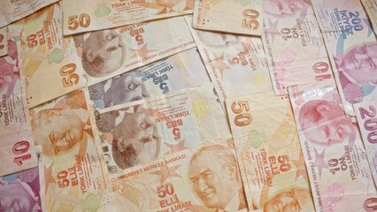 Scattered turkish banknotes display various denominations including 50, 10, 5, and 200 lira, highlighting the country's currency in a rich, colorful palette.