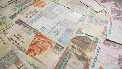 Egyptian banknotes of various denominations scattered, highlighting colorful currency notes, financial concepts, egyptian economy, and national heritage.