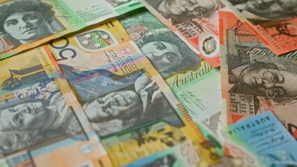 Australian banknotes in various denominations scattered, highlighting vibrant colors, intricate designs, and diverse portraits, capturing australia's unique currency details vividly.