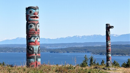 Vibrant totem pole with bear salmon raven by serene river
