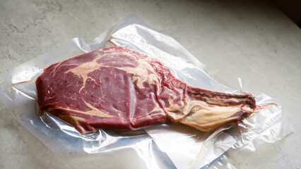Vacuum-sealed beef steak placed on kitchen counter showcasing fresh meat in transparent packaging for cooking or grilling