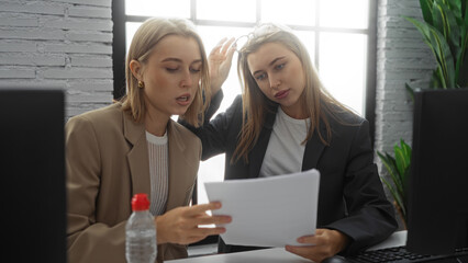 Women reviewing documents in modern office setting with natural light, showing teamwork and...