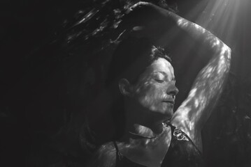 Retrato de mujer con ojos cerrados con luces y sombras en blanco y negro 