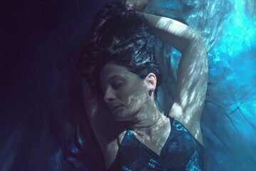Retrato de mujer recostada con luces y sombras en tonos azules