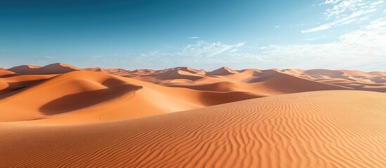 Naklejka premium Vast Orange Dunes of Sahara Desert under a Clear Blue Sky