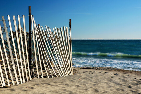 Wooden sand fence on the beach near the water's edge