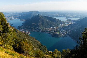 Obraz premium Panoramic view of lakes and surrounding mountains near Belvedere del Parco Valentino at Piani Resinelli, Valsassina, Italy. Aerial view of province of Lecco, near Monte Coltignone and Cima Paradiso