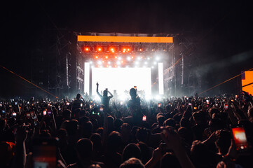 Crowd cheering and filming live music concert