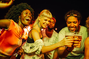 Friends toasting with beer at music festival