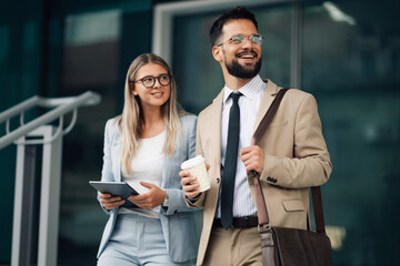 Business people walking and talking outside office building