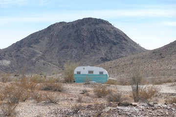 Small camper sitting in the middle of the desert