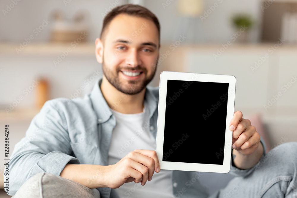 Poster happy young man showing tablet computer with mockup for website or application on screen, indoors. s