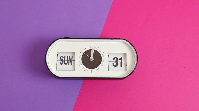 Alarm clock with the time and date of Easter on a lilac-pink background.