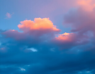 Obraz premium Toned Dramatic Sky with Orange and Pink Clouds – Enchanting Sunset Cloudscape.A stunning dramatic sky with shades of blue and gray creates a beautiful backdrop for a sunset. Soft orange and pink cloud