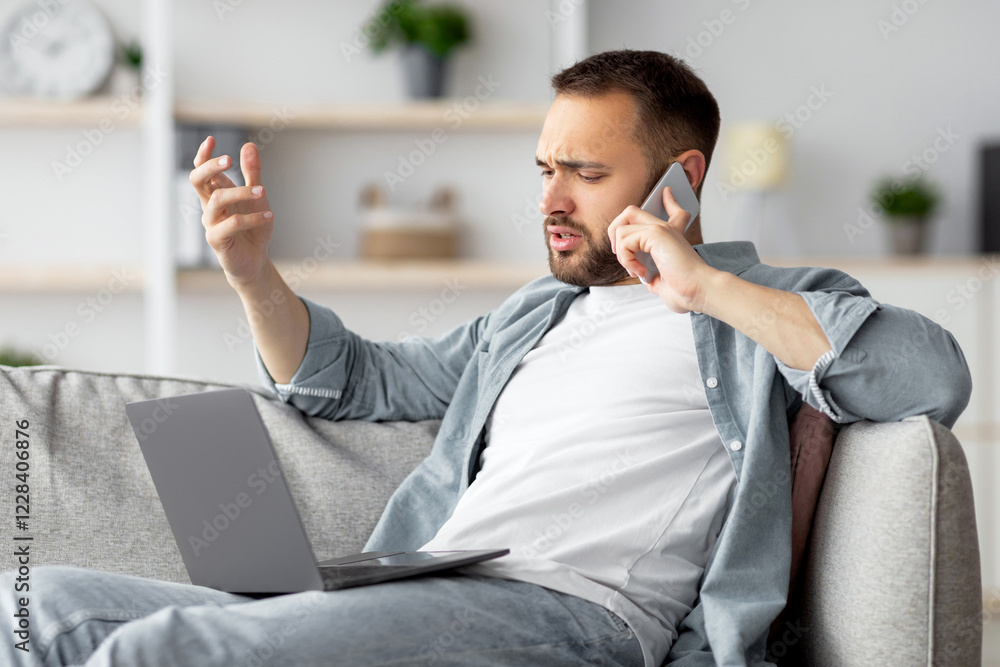 Aufkleber stressed young businessman using laptop and making call on mobile phone from home office. millennial