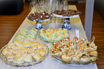 Cocktail table with mini burger, canapés, pistachio croissant and dark chocolate for the cocktail