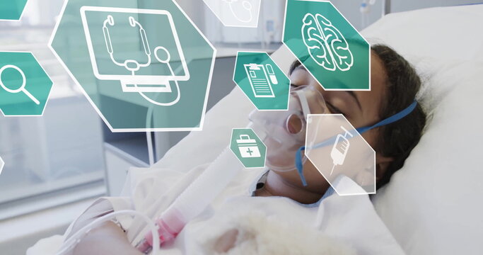 Image of medical icons over biracial girl wearing oxygen mask in hospital - Powered by Adobe