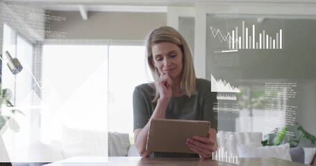 Image of financial data processing over caucasian woman using tablet