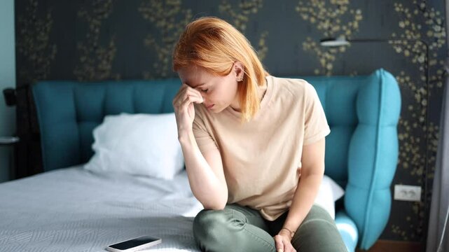 Depressed woman sitting on her bed