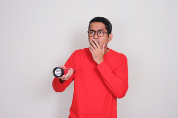 A man holding flashlights showing shocked face when looking at something
