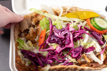 yummy doner kebab with salad and garlic sauce in a takeaway tray 