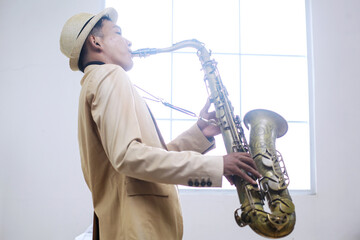 Saxophonist Enjoy Playing Against Window Background 