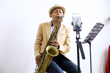 Saxophonist Recording A Vlog And Live Streaming Using Smartphone At Music Studio 