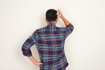 Back view of a man scratching his head showing confused expression