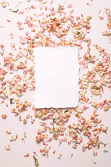Empty card surrounded dried petals confetti.