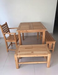 Lightly Hued Wooden Dining Set Arranged Gracefully Against White Wall