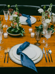 Elegant dinner table setup featuring floral arrangements and fine dining items for a special occasion in an indoor venue