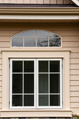 Fototapeta premium Elegant Home Exterior with Classic White Window Design. High-quality image showcasing beautiful architecture, perfect for real estate, home improvement, and design websites.