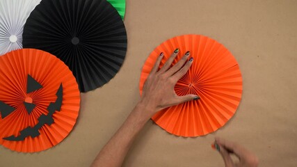 Making orange paper rosettes for Halloween crafts on table with creative touch - Powered by Adobe