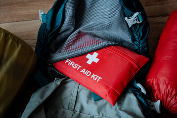 A wellequipped first aid kit is conveniently placed on top of a sturdy backpack, ready to provide...