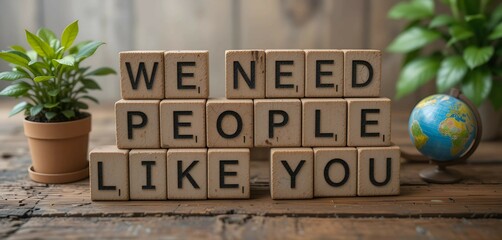 Wooden blocks with "We Need People Like You" text, conveying motivation, teamwork, encouragement, and community support in a positive message.