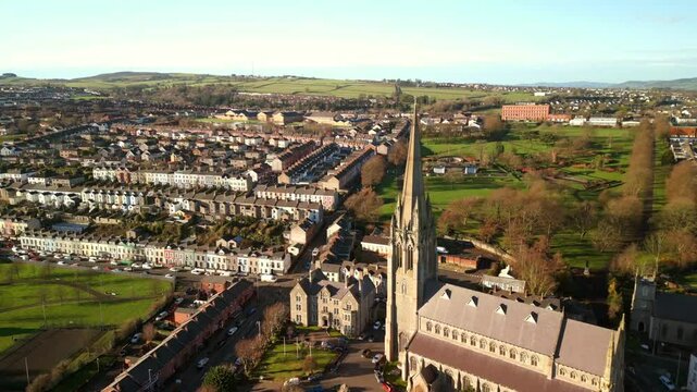 Wide, forward moving aerial shot of St Eugene's Church and The Creggan area of Derry-Londonderry on a bright and sunny day. Filmed in 4K, 60fps and in Rec709 color.